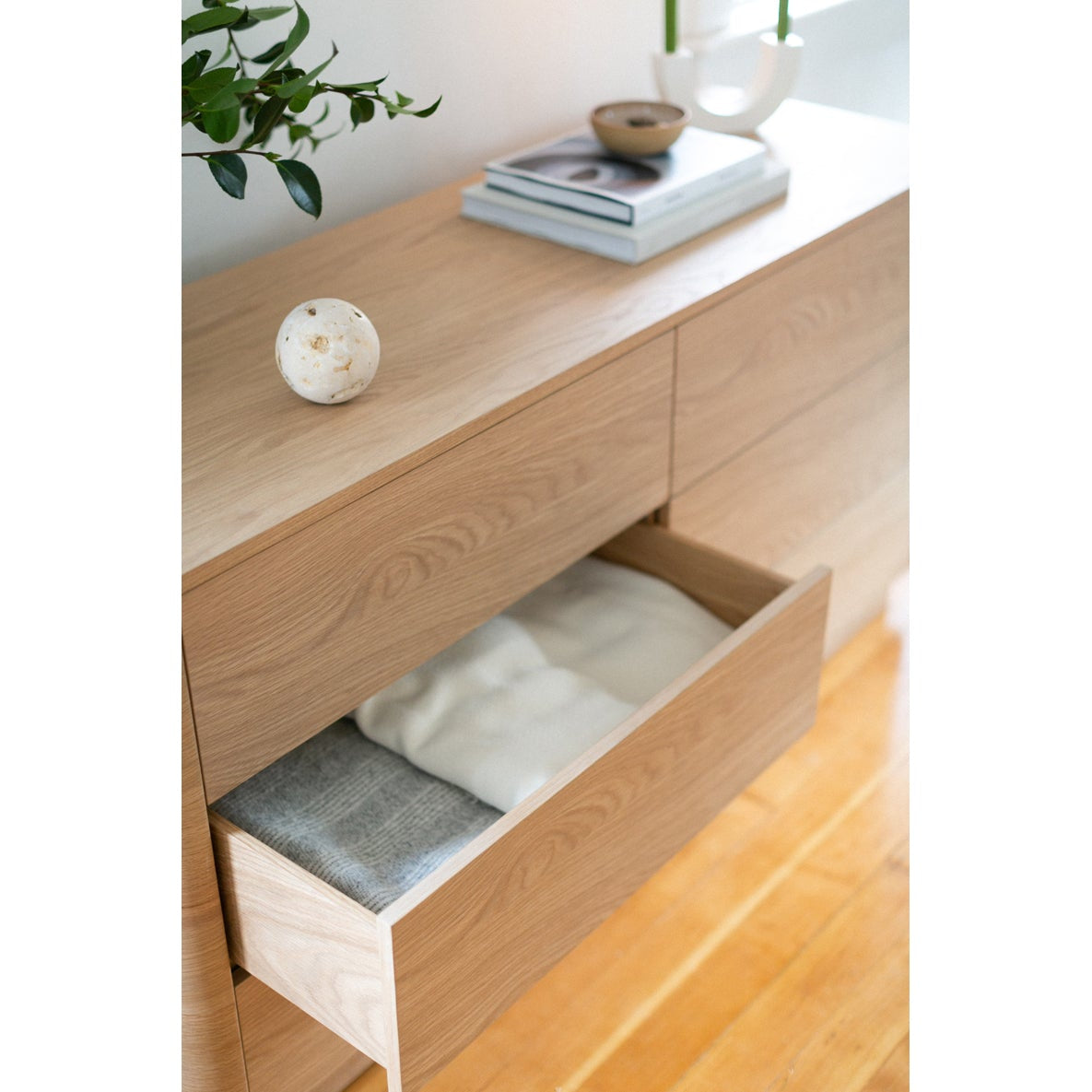 Wooden dresser with open drawer on a white background