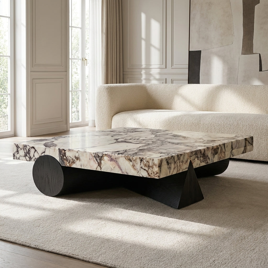 Modern coffee table with marble top and black legs in a living room setting
