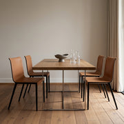 Dining table with four chairs in a minimalistic room.