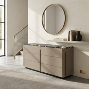 Modern kitchen with a beige island and round mirror on the wall.