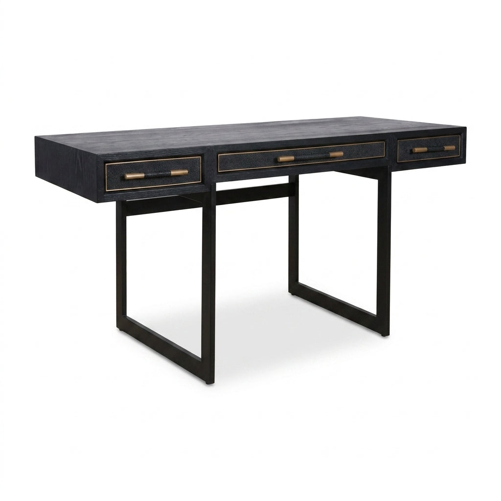 A modern writing desk with a black textured wood top, three drawers with brass handles, and a black metal frame base, shown on a white background.