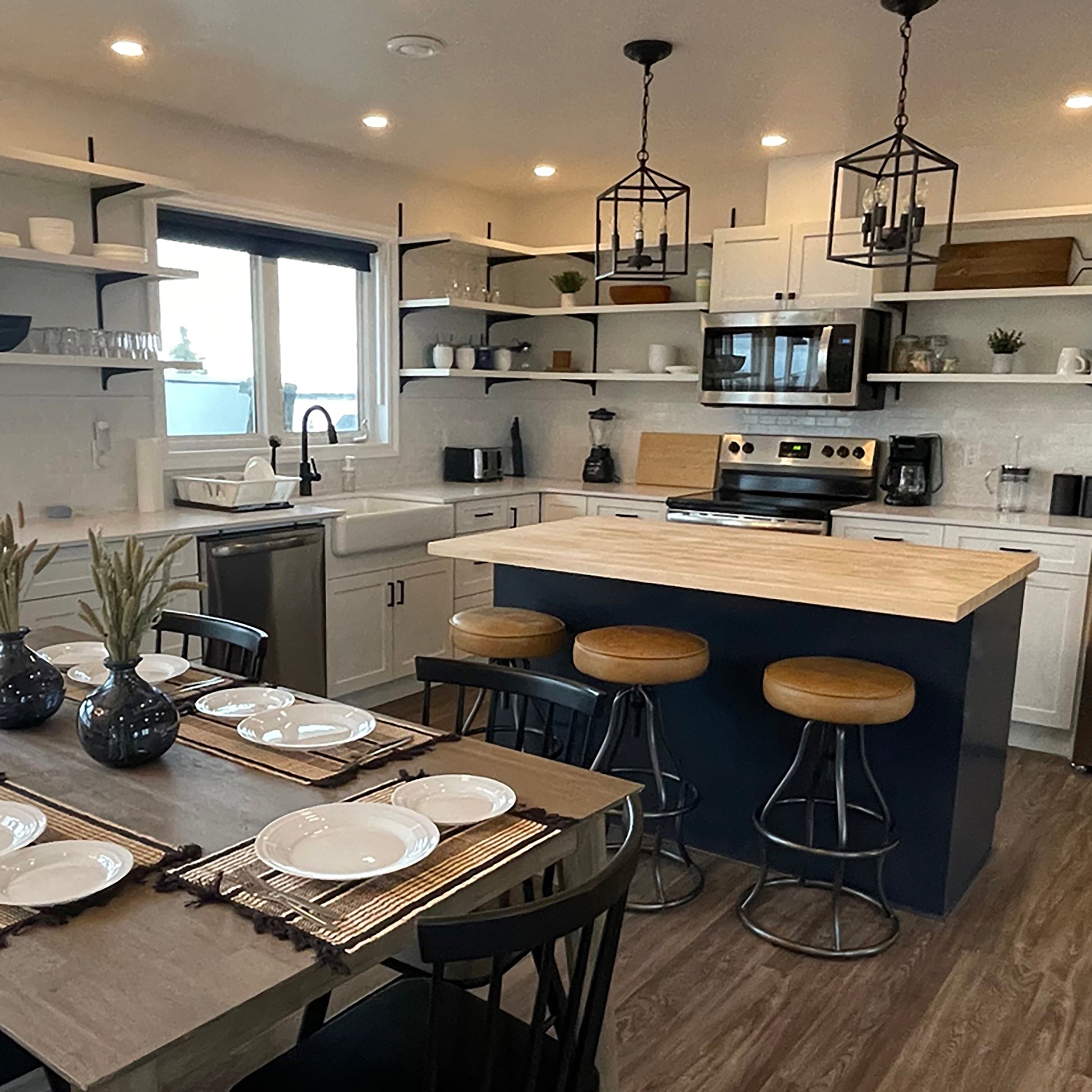 Modern kitchen with a dining area, island, and various appliances.
