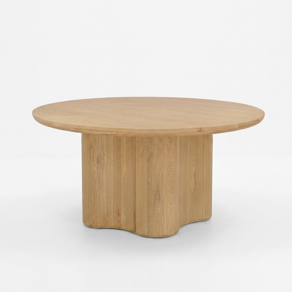 A round wooden coffee table with a light oak finish, featuring a fluted pedestal base, shown against a plain white background.