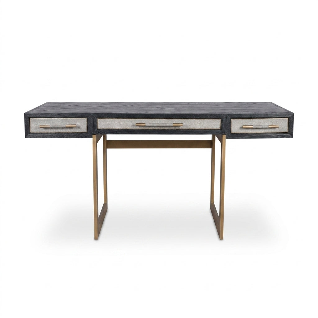 A modern writing desk with a dark gray textured top, three drawers with light beige fronts and gold handles, and a gold metal frame.