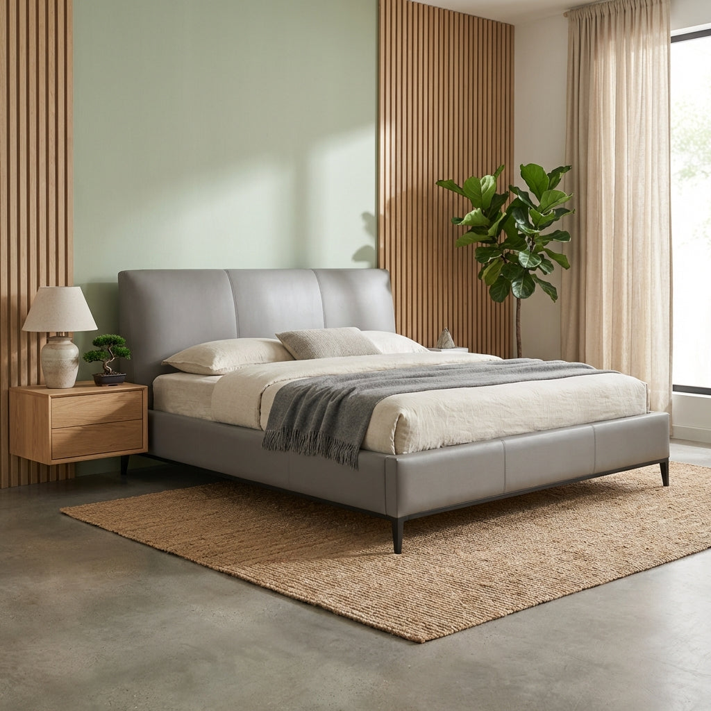 Modern bedroom with a gray upholstered bed, wooden nightstand, and decorative elements.