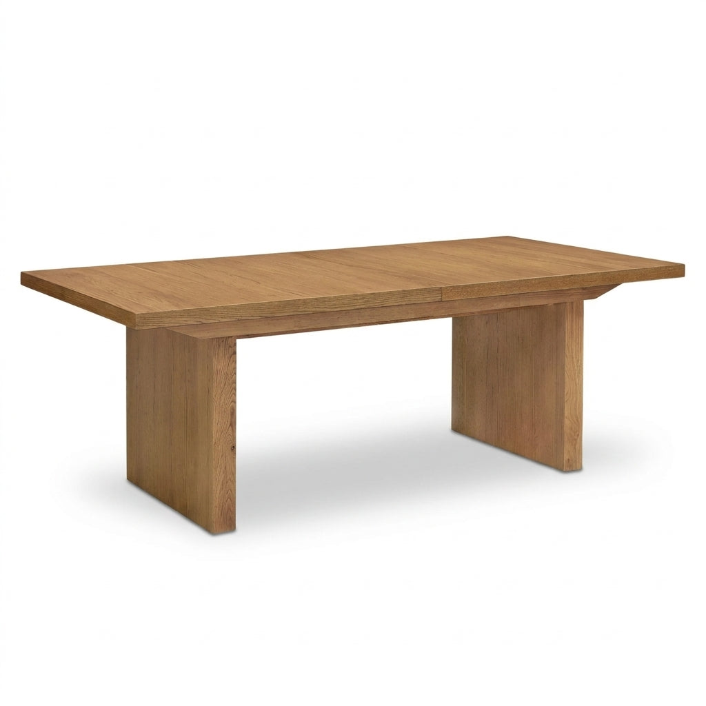 A rectangular wooden dining table with a warm medium-brown finish, featuring a thick tabletop and blocky pedestal legs, shown on a plain white background.