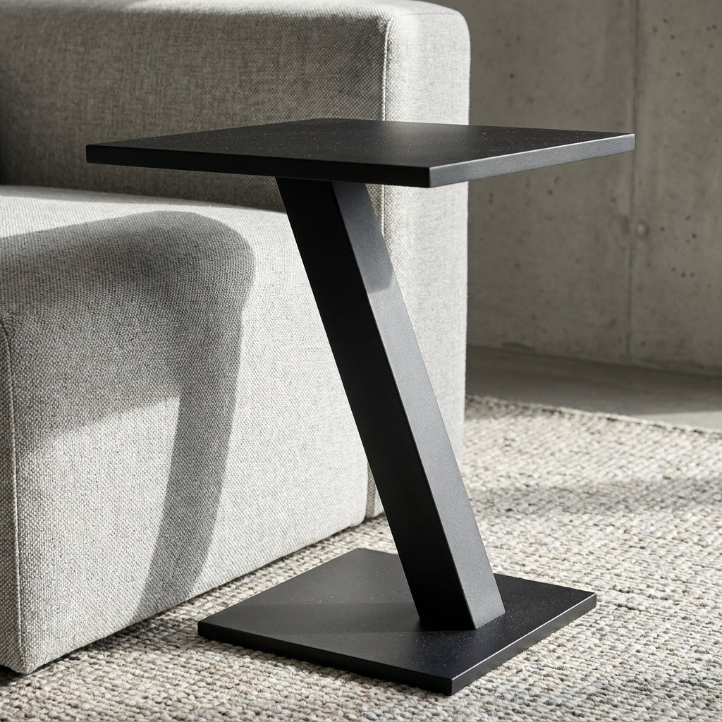 Black side table with a modern design next to a gray sofa.