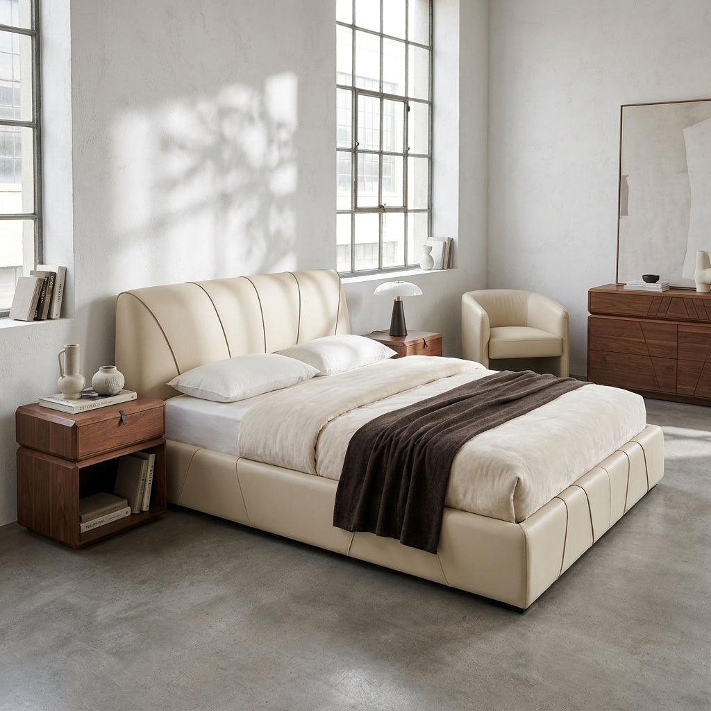 Beige upholstered bed in a modern bedroom with wooden nightstands and a chair.