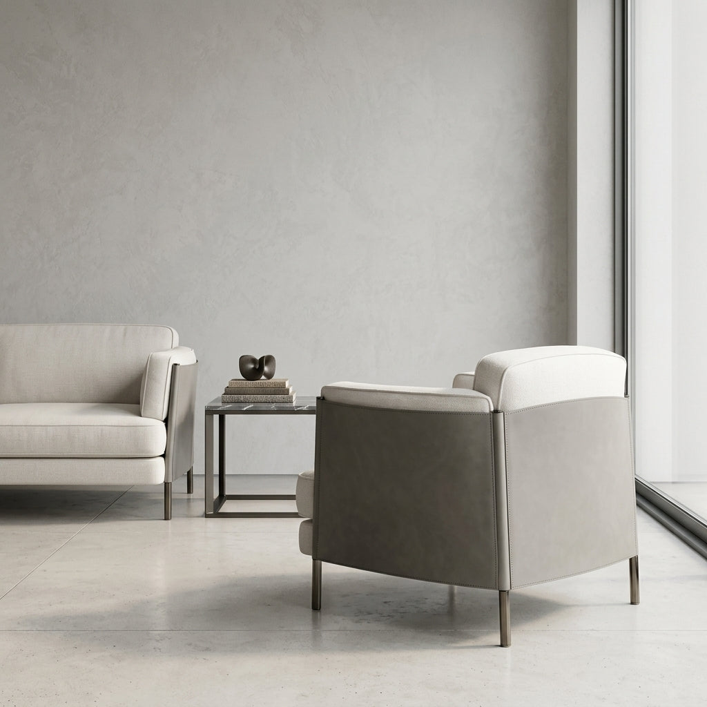 Modern living room with a gray armchair and sofa against a neutral wall.