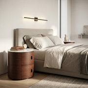 Modern bedroom with a bed, nightstands, and wall sconce.