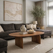 Deia oval acacia coffee table with slab legs in a living room