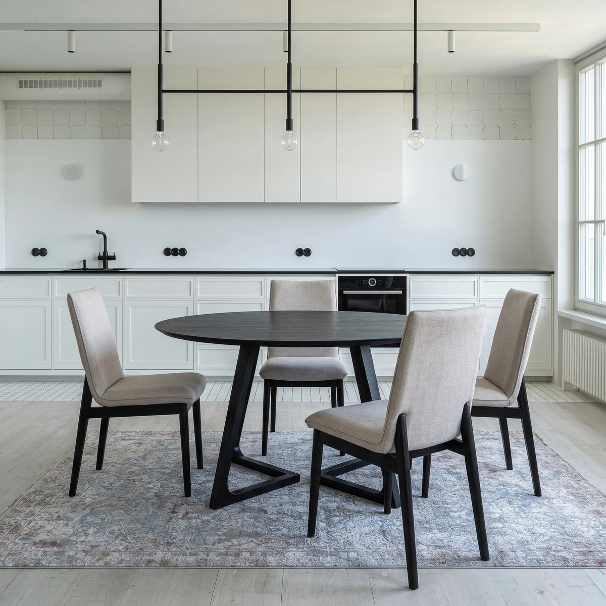 Gisborne Round Dining Table in Black with 4 Cole beige dining chairs in a white kitchen
