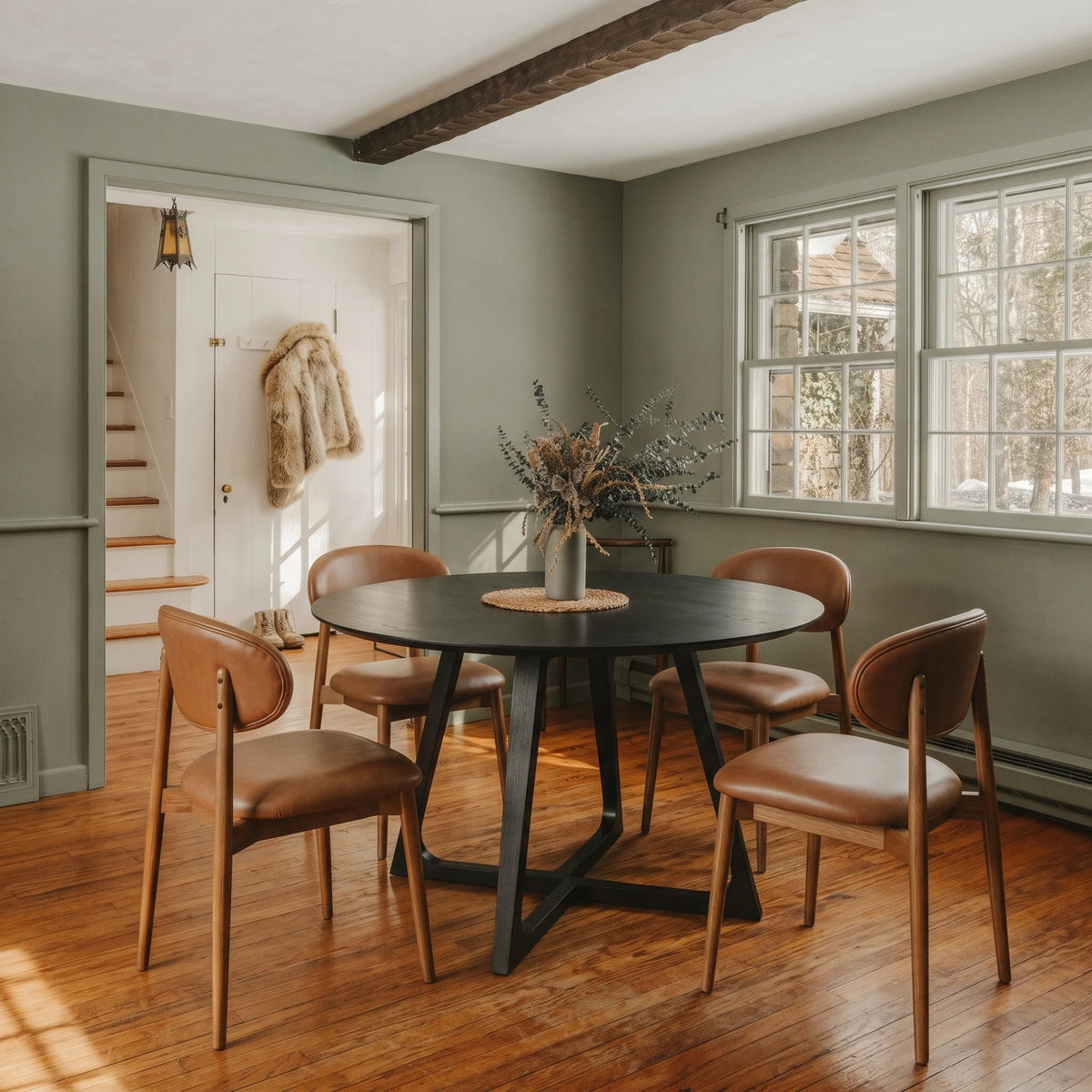 Gisborne Round Dining Table in Black with 4 Etta leather dining chairs in a sage green dining room
