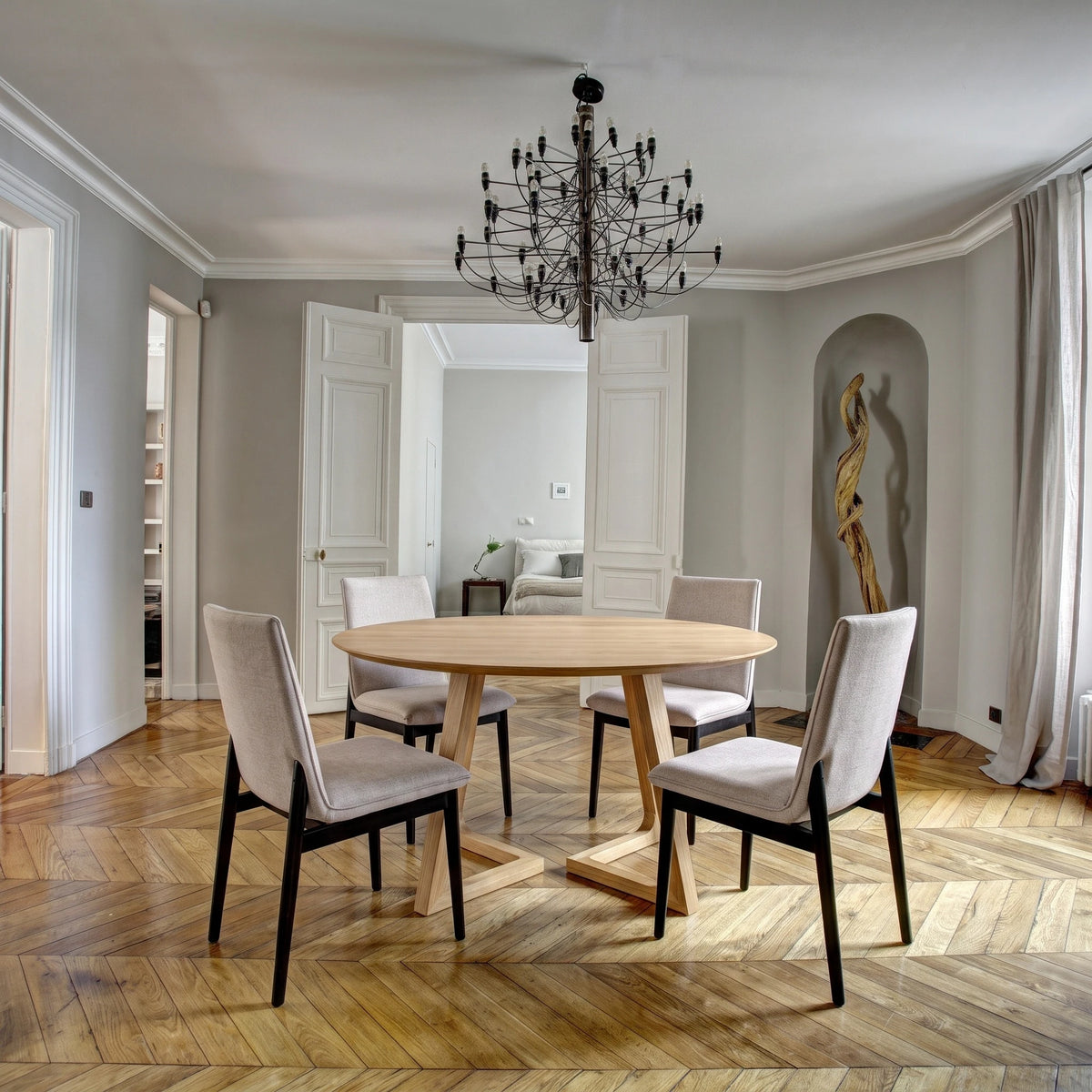 Gisborne Round Dining Table in Natural Oak with 4 Cole beige dining chairs on a parquet floor