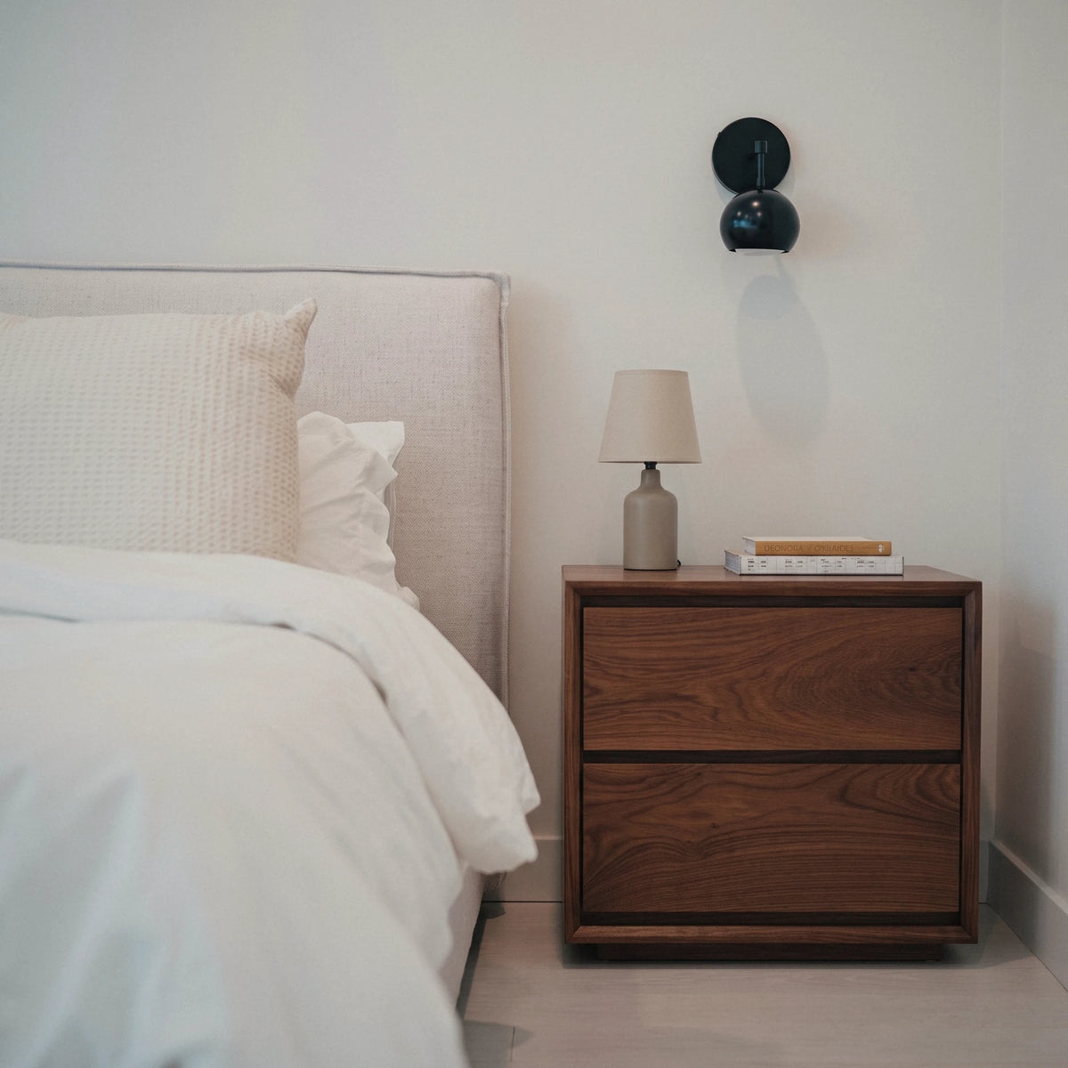 Timberton Nightstand in Black Walnut beside a bed